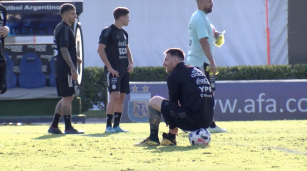 Lionel Messi se ata los cordones sentado sobre un balón en entrenamiento en Ezeiza previo al Mundial Qatar 2022